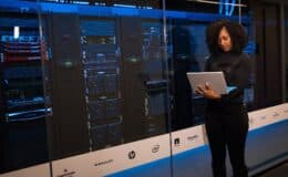 software engineer standing beside server racks