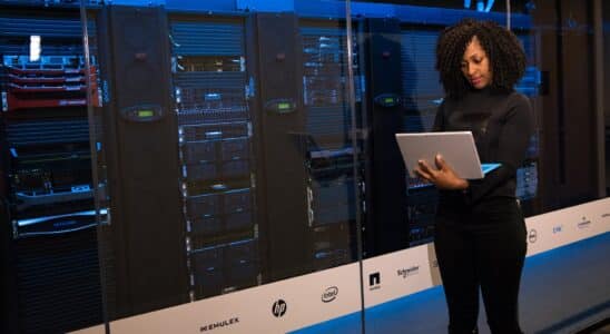 software engineer standing beside server racks