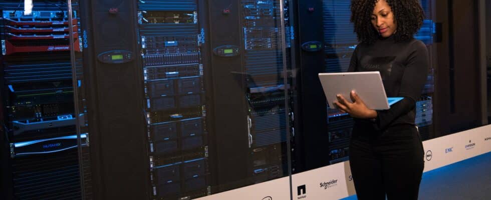 software engineer standing beside server racks