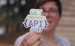 programmer holding a paper cutout with an api quote