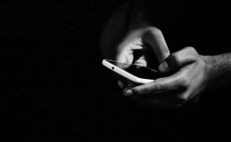 grey scale photo of person holding smartphone