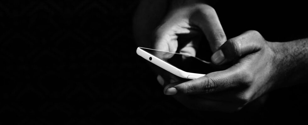 grey scale photo of person holding smartphone